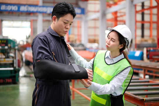 Engineer or technician wearing bandages splint, pain in elbow in arm and coworker encourage him in the factory