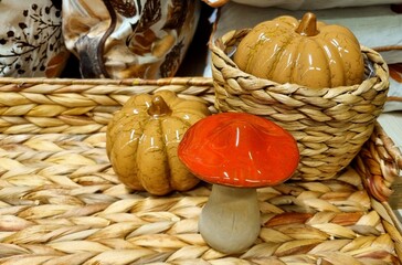 Autumn home decor with pumpkins and a wicker natural stand, pumpkins and a mushroom on a natural...