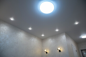 Modern stretch ceiling with LED chandelier and spotlights, modern renovation