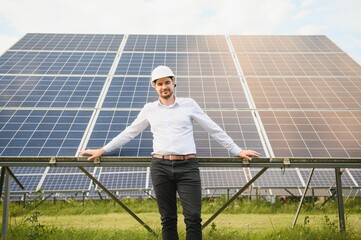 Young architect standing by solar panels