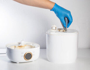 Wiping and cleaning scale and rust from a chemical agent in a humidifier. Hand in a blue glove....