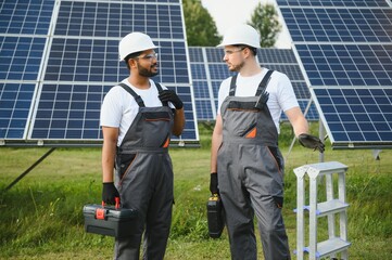 Two skilled workers or craftsmen wearing working gray uniforms, technicians are installing solar...
