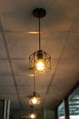 Classing ceiling lighting lamp with metal cage that glowing in warmlight shade. Interior decoration...
