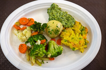 Boiled broccoli with vegetables on a disposable plate. Diet and healthy eating
