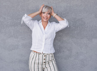 Panicking adult woman stare to you, against gray background - wall. Mistake. Bad news