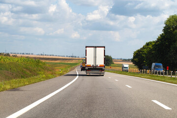 A truck with a semi-trailer delivers cargo along the highway to the marketplace. Delivery service...