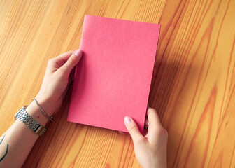 Hands Holding a Blank Red Notebook