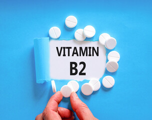 Vitamin B2 riboflavin symbol. Concept words Vitamin B2 on beautiful white paper. White pills...