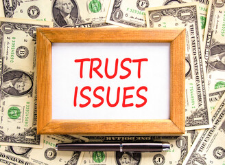 Trust issues symbol. Concept word Trust issues on beautiful wooden picture frame. Dollar bills....