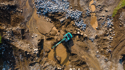 Excavator and dump truck working in rock and sand mine, Construction and mining site view from above.