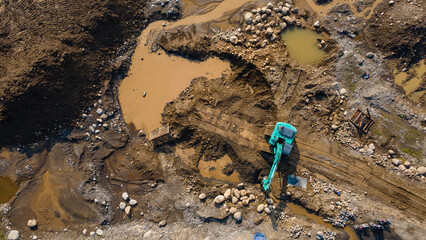 Excavator and dump truck working in rock and sand mine, Construction and mining site view from above.