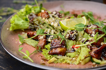salad with greens, lime and meat in a plate macro photo