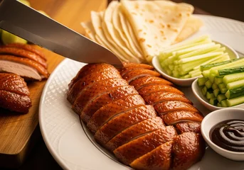 Fotobehang Peking Glossy roasted Peking duck caught mid-carve with warm lighting and golden tones  © Maria