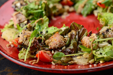 fresh salad with chicken and cherry tomatoes in a red plate macro photo