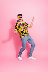 Fototapeta premium Young cheerful man in vibrant floral shirt and sunglass enjoying a good mood against a bright pink background