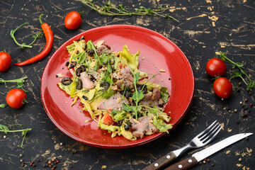 salad with ham and fresh iceberg lettuce and olives in a red plate