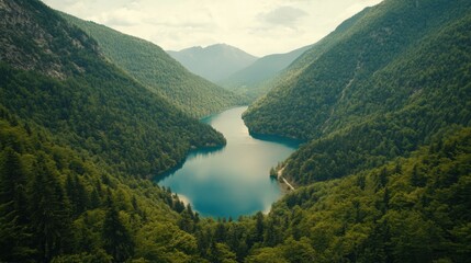 A breathtaking aerial view of a stunning blue lake nestled in a green mountain valley, with a winding river flowing into it.