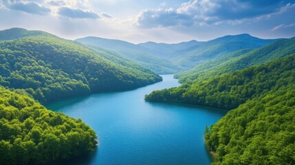 A breathtaking aerial view of a stunning blue lake nestled in a green mountain valley, with a winding river flowing into it.