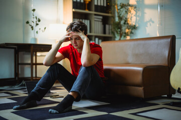 Depressed teen sitting alone on floor, head in hands, experiencing overwhelming emotional distress...
