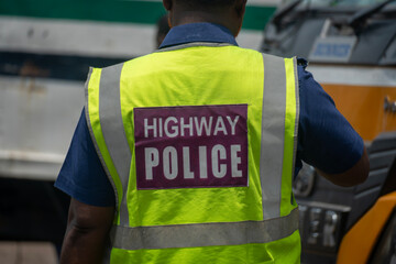 Back view of a highway police officer wearing a neon reflective vest