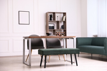 Wooden table with chairs, bench and decor in dining room. Interior design