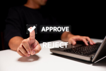 A person deciding on an action at a laptop, with visible options to approve or reject displayed on...