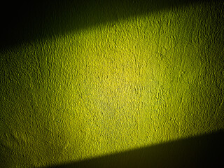 Dramatic diagonal ray of light on the green wall background