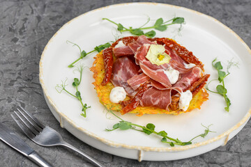omelet with ham and herbs in a white plate on a gray background macro