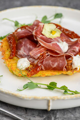 omelet with ham and herbs in a white plate on a gray concrete background macro