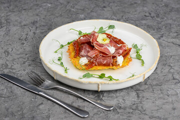 omelet with ham and herbs in a white plate on a gray concrete background
