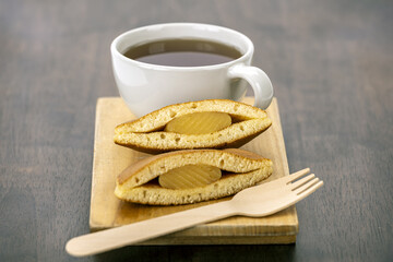 Tea pancake wooden fork dessert sweet snack breakfast hot drink brown cup wooden board filling baked pastry cozy inviting delicious treat homemade afternoon break comfort warm beverage plate