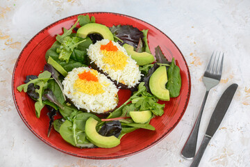 Cheese and avocado salad with herbs on a plate