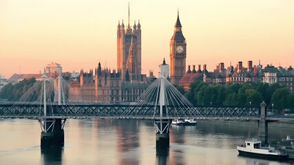 London, United Kingdom. Aerial view of London skyline during sunset with Big Ben and Houses of Parliament in the foreground. The sky is painted in soft hues of orange and pink. - Powered by Adobe