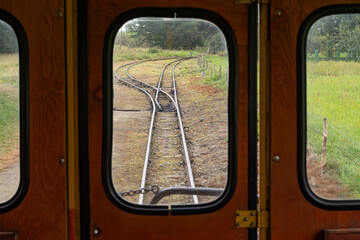 View through vintage train doors of a railway switch in the countryside, symbolizing choice,...