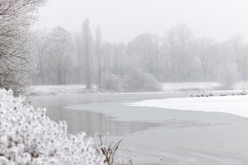 Eine dünne Schneedecke liegt über dem See, der Nebel dominiert, die Sonne kann sich noch nicht...