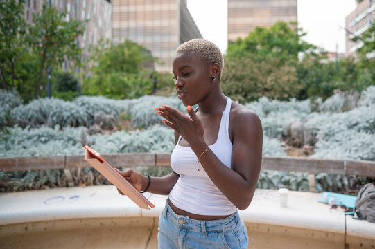 Young woman gesturing while reading a script in a park