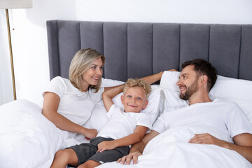 Fototapeta premium Happy family spending time together on bed at home