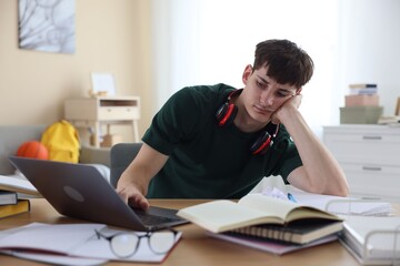 Obraz premium Tired student preparing for exam at table indoors