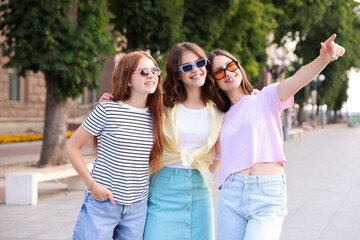 Happy friends walking together on city street