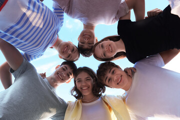 Group of happy teenage friends spending time together outdoors, bottom view