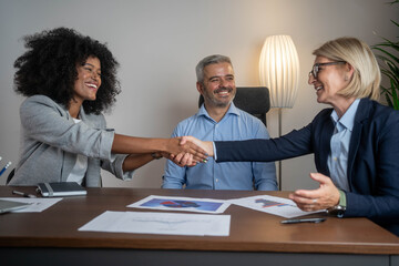 Business people handshake celebrating successful contract agreement with applause during meeting in modern office partnership