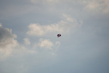 A Kite in Cloudy Sky – Aerial Descent Against Blue and White Backdrop