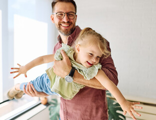 Portrait of father and little daughter having fun at home, family life, parenting, love and bonding...