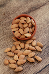 Close up of fresh almonds spilled out of bowl