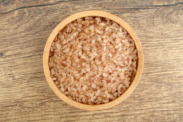 Brown rice in wooden bowl