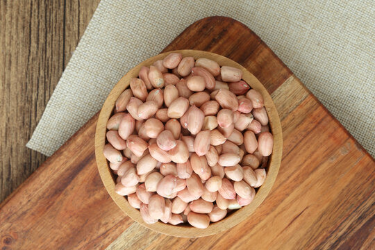 Top view of wooden bowl with peanuts