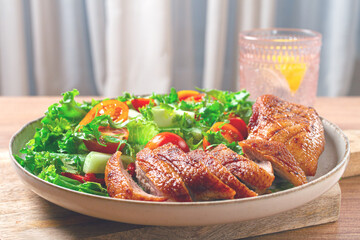 Delicious grilled duck breast served with fresh garden salad and cherry tomatoes at a rustic dining...