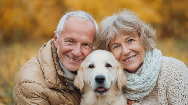 Portrait of happy senior couple with a dog sitting in a park. Happy elderly man and woman, with golden retriever puppy. Healthy elderly couple with pet, outdoors. Cute pet and owners.