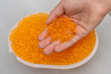 The silica gel is orange in the hand.Orbisa balls for shooting.Water balls.