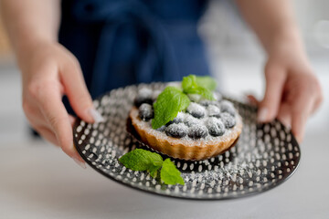 Girl Holding Blueberry Dessert At Home In The Kitchen Close-Up